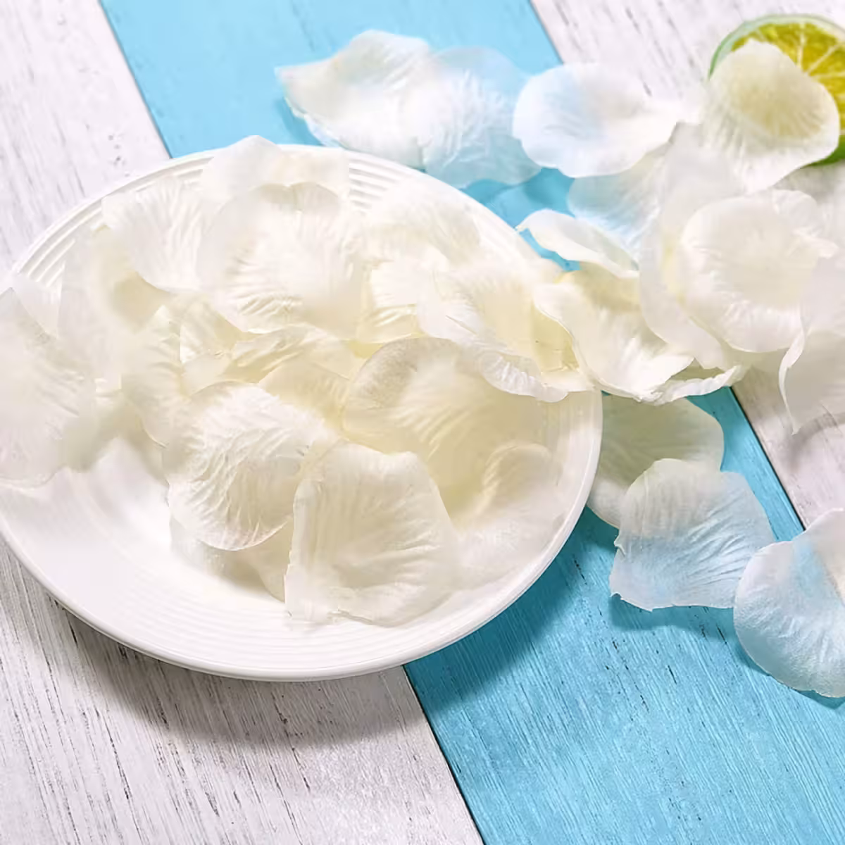 Beli umetni cvetni listi razpršeni po tleh za elegantno dekoracijo